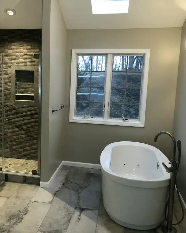 A freestanding tub beside a tiled walk-in shower