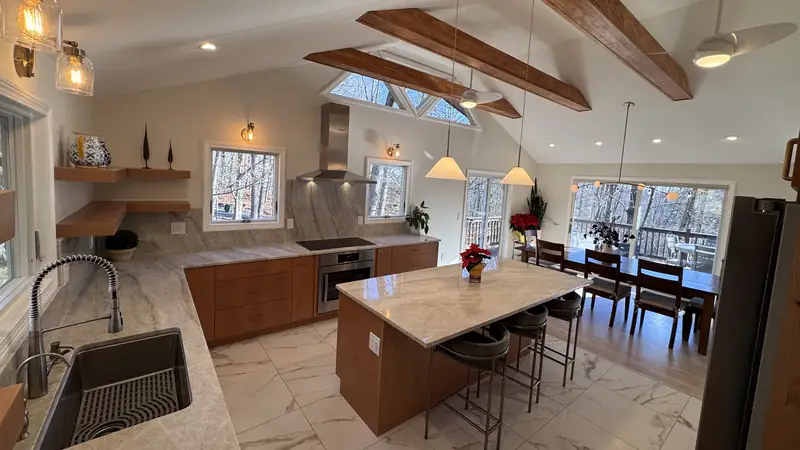 A remodeled kitchen in Kinnelon with wood cabinets, a white stone island and exposed ceiling beams